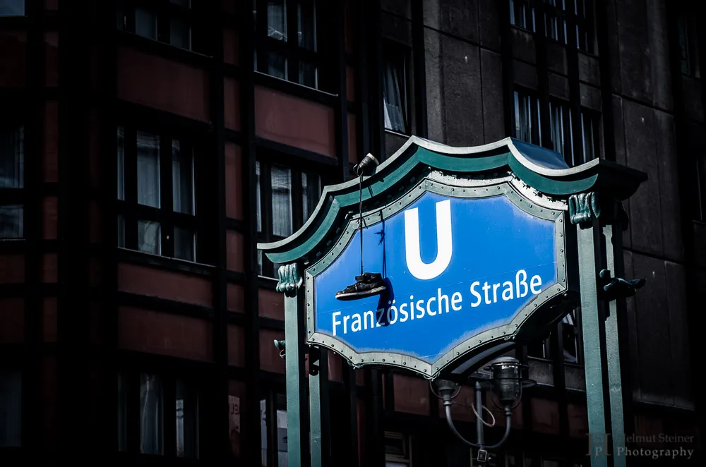 Subway sign of Französische Straße in Berlin with shoes hanging down of it