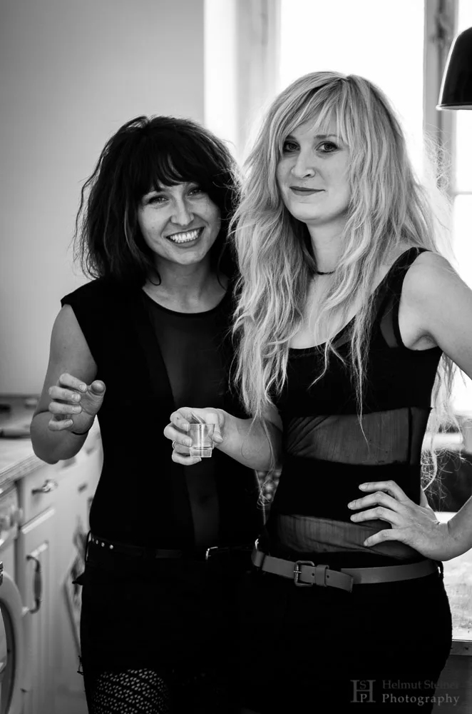 Two young women taking shots before going out. They are dressed up for a theme party in Berlin.