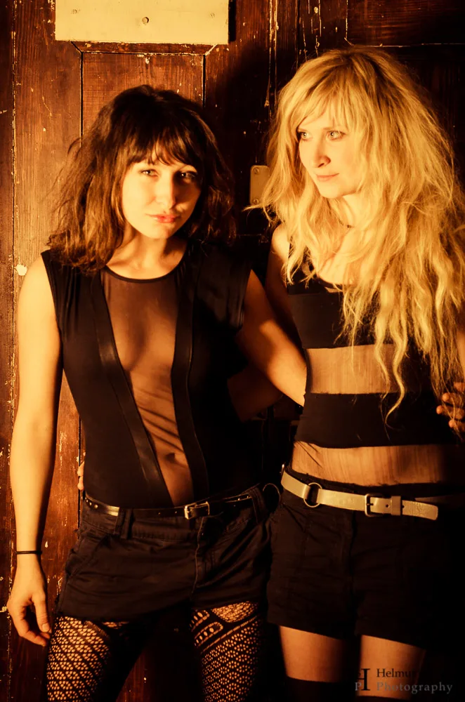 Two young women standing in the doorway. They are dressed up for a theme party. Berlin.