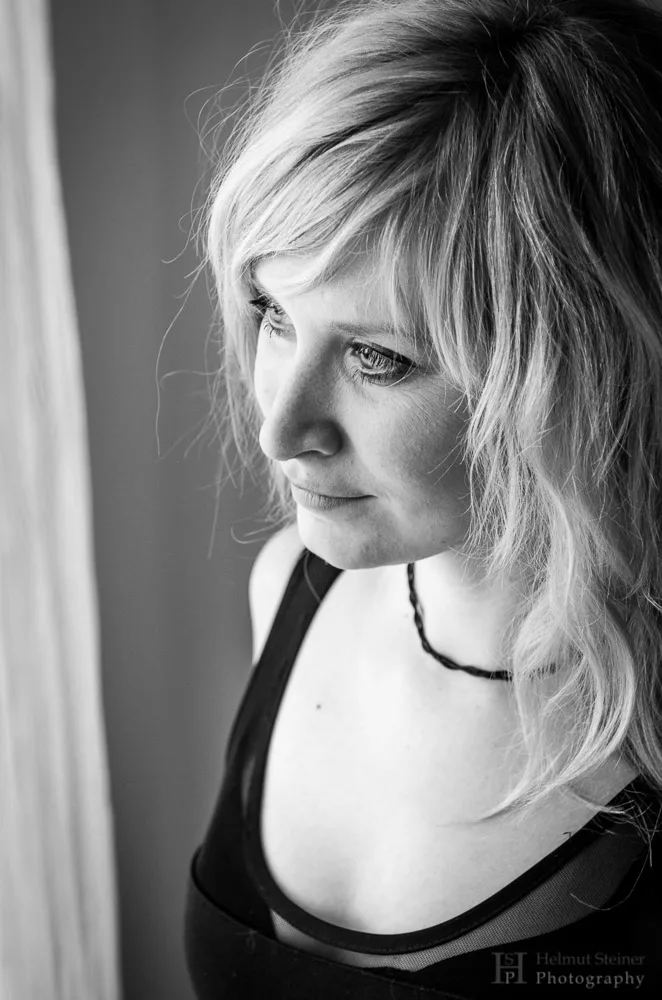 Young blonde girl looking out of the window