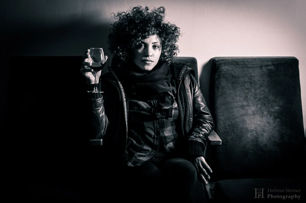 Young woman with curly hair holding a wine glass