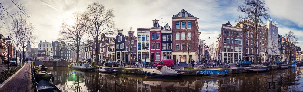 A panorama of a canal in Amsterdam showing leaning houses