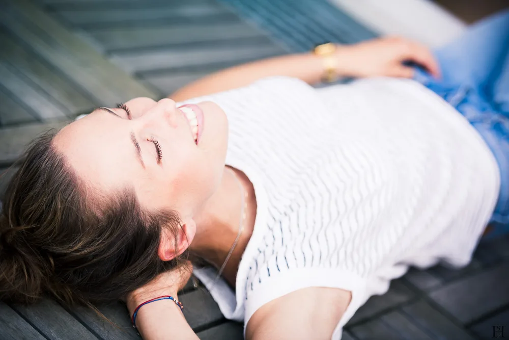 Young beautiful girl lying on a wooden floor smiling