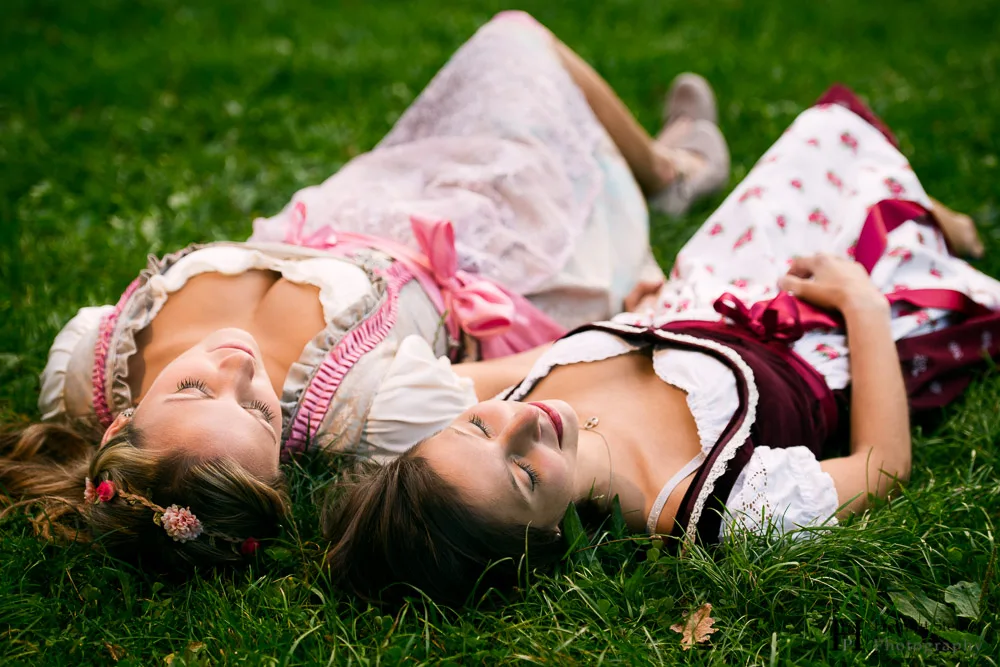 Girls in traditional German/Austrian dresses (called Dirndl) lying in the grass.