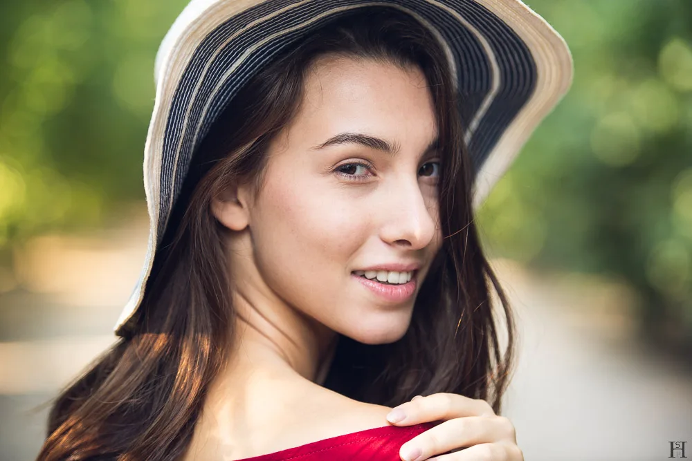 junge, hübsche Frau mit Hut im Park